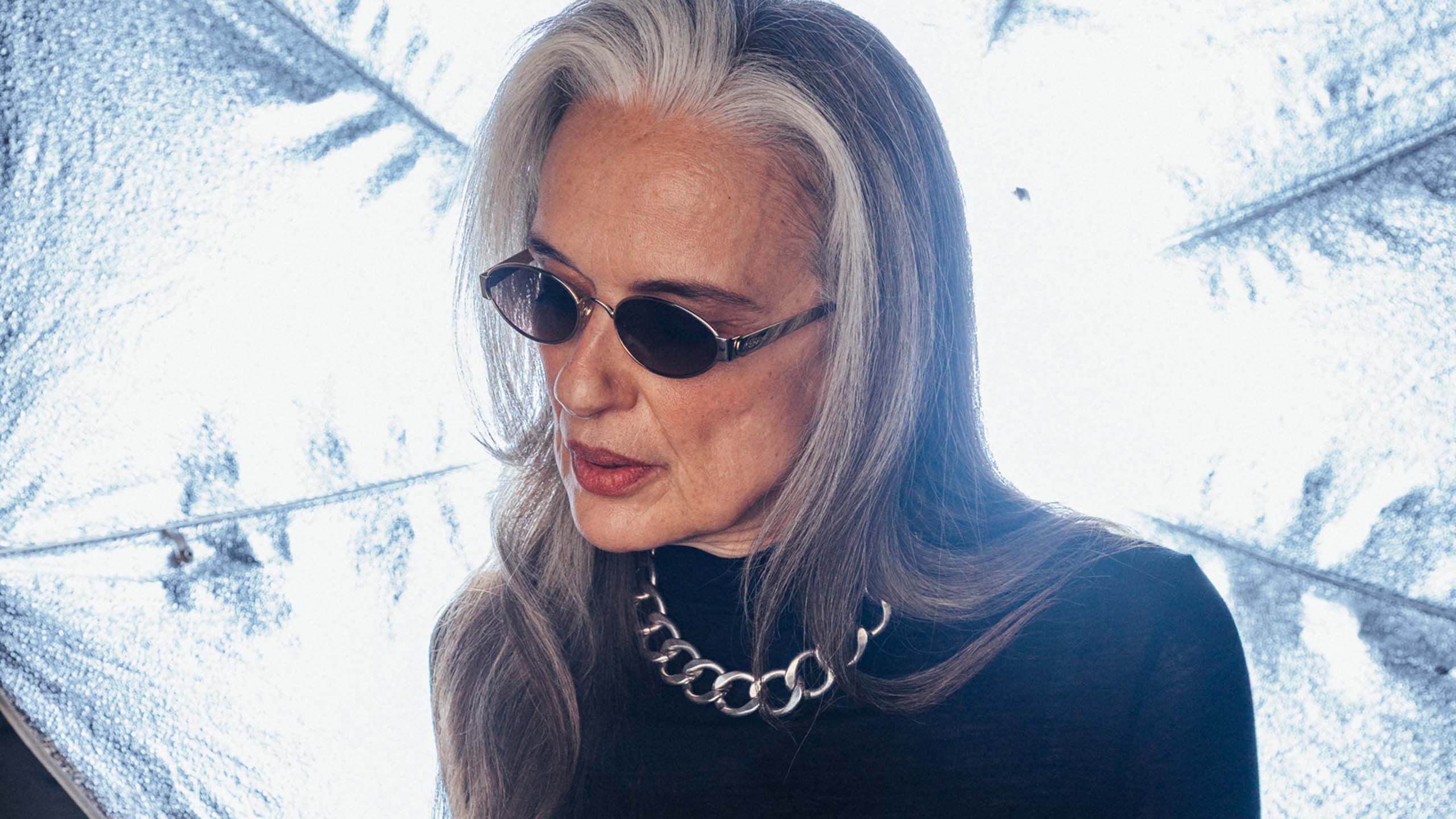 Tyylik&auml;s vanhempi nainen trendikk&auml;&auml;t aurinkolasit kasvoilla